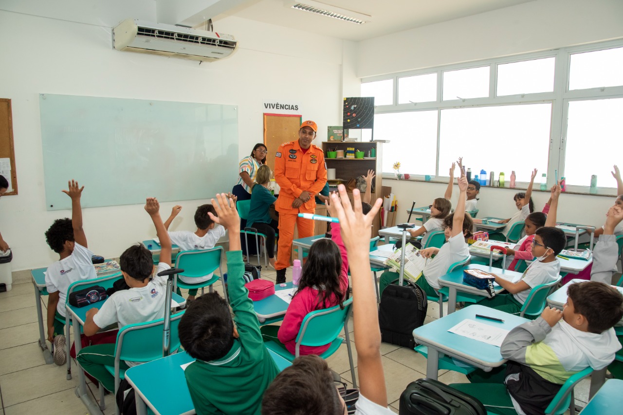 Em sala de aula, bombeiro conversa com alunos da 