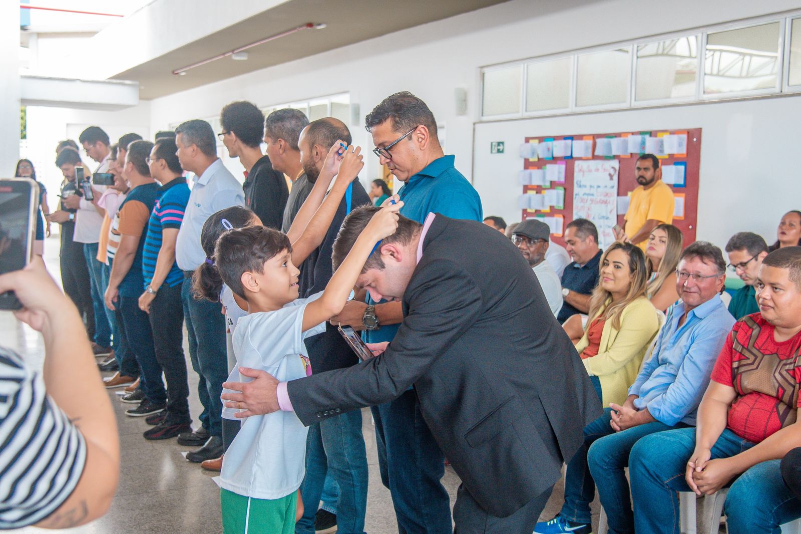 Pais recebem medalhas após participarem de brincadeiras com os filhos