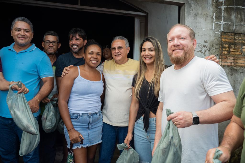 Presidente da Assembleia e a presidente do Gedema com moradores de município contemplado com as doações de pescado e cestas básicas