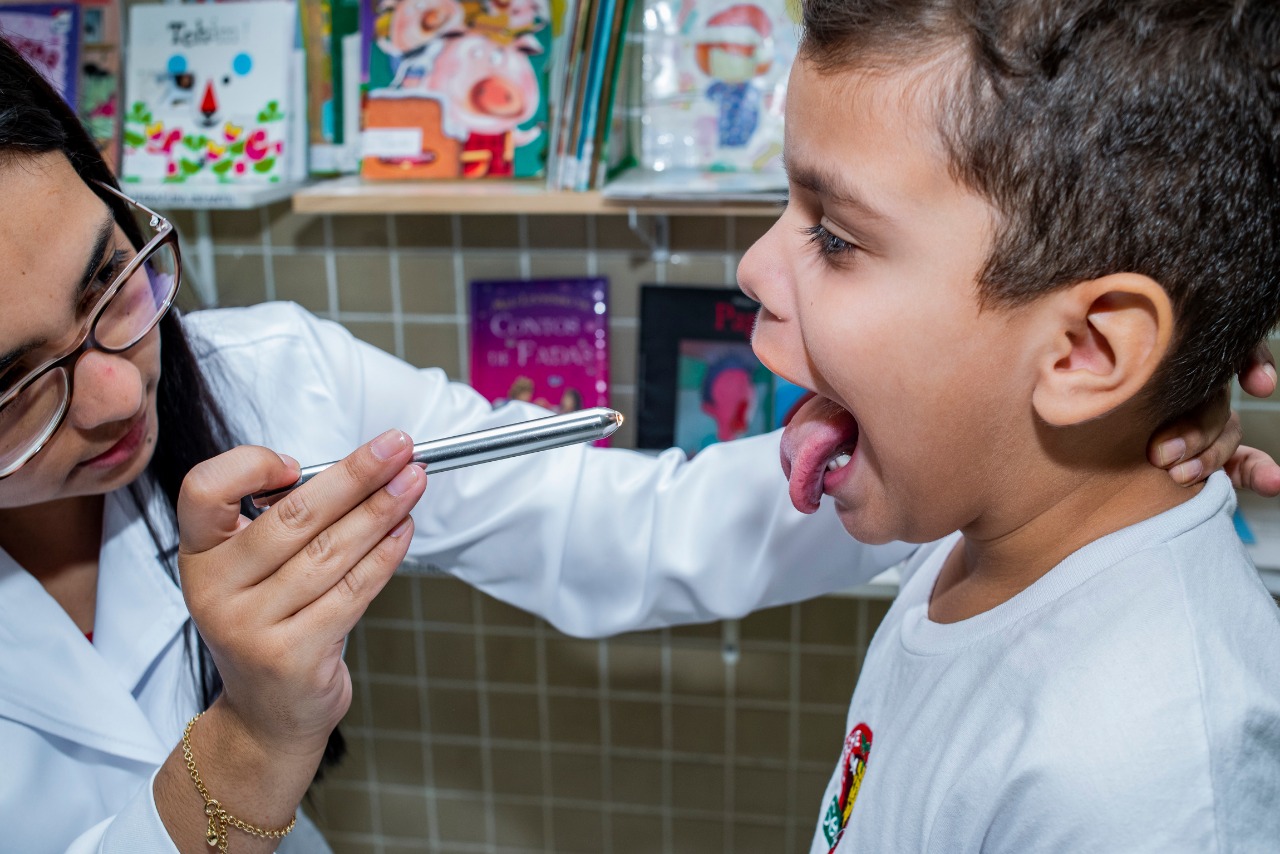 A clínica geral verifica garganta de aluno da Creche-Escola Sementinha