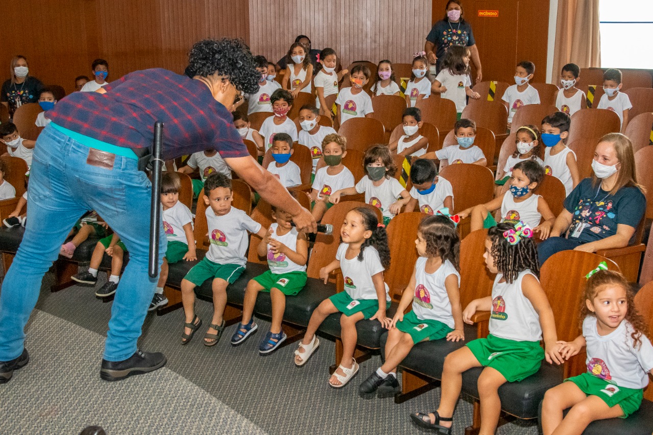 Aluna da creche canta com professor durante atividade de musicalização realizada no encerramento da programação 