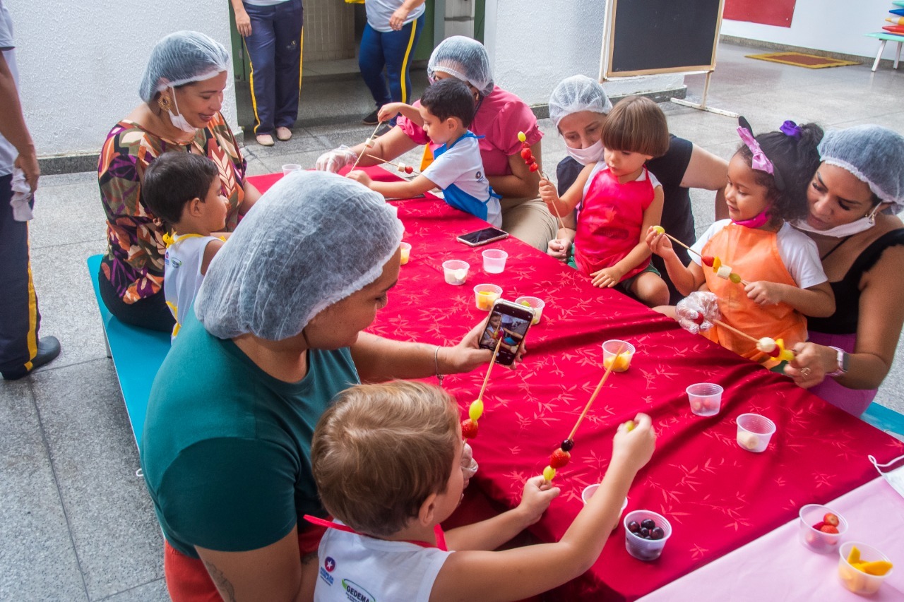 Alunos e mães durante a montagem de espetinhos de frutas