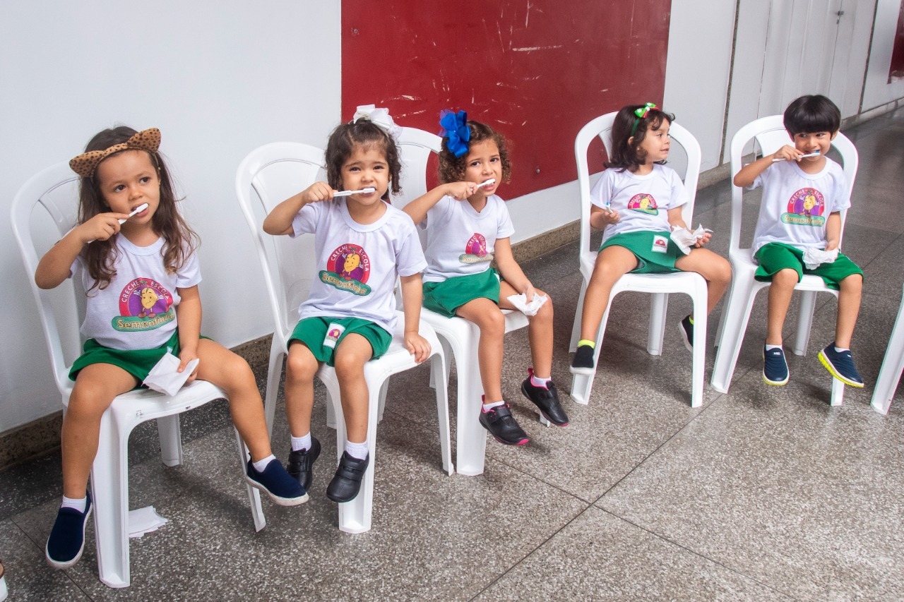 Crianças aprendem a maneira correta de escovar os dentes durante a atividade prática