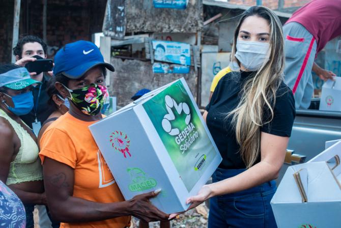 Dona de casa recebe cesta básica das mãos de Ana Paula Lobato durante ação do Gedema Solidário