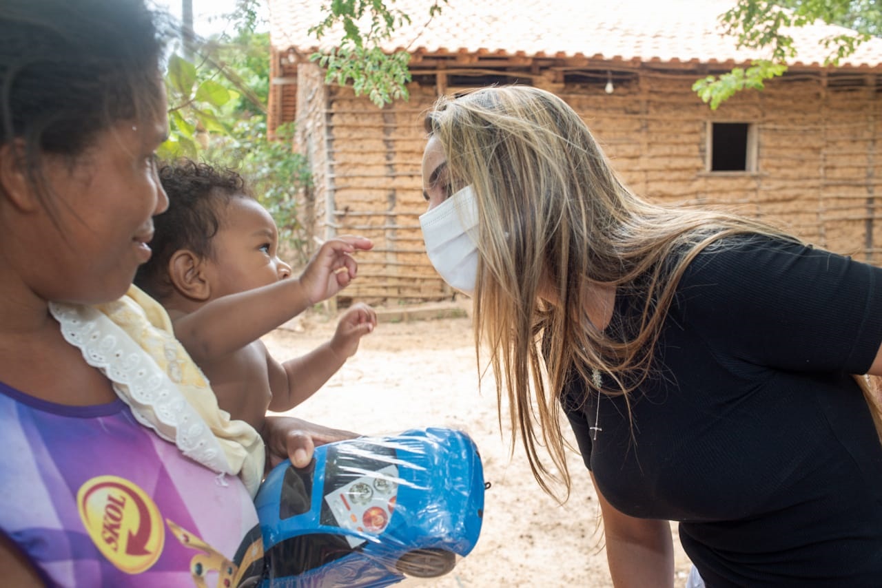 Ana Paula brinca com bebê durante entrega de brinquedos em povoado de Pinheiro 