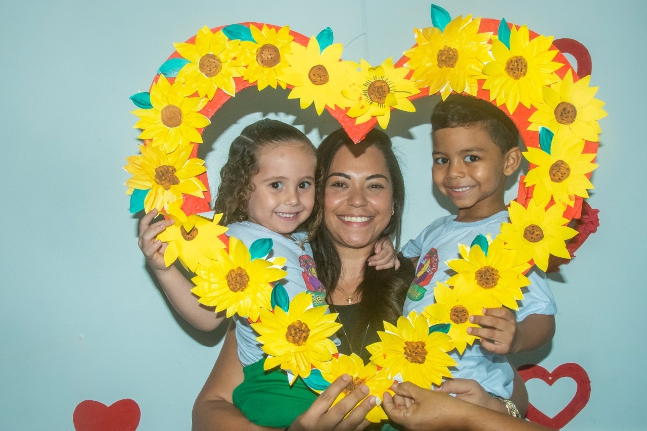 Mãe e filhos são emoldurados por um coração de flores: afeto e interação marcaram as atividades na Creche