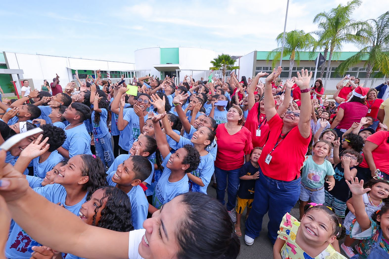 Alunos e professores esperam ansiosos pela descida de Papai Noel do helicóptero 