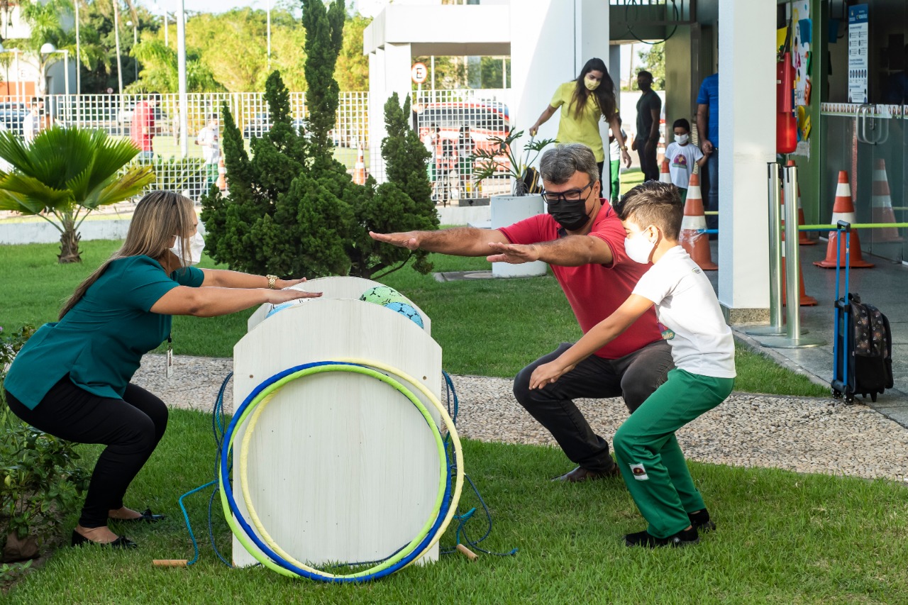 Pai e filho fazendo agachamento durante a brincadeira em homenagem ao Dia dos Pais 