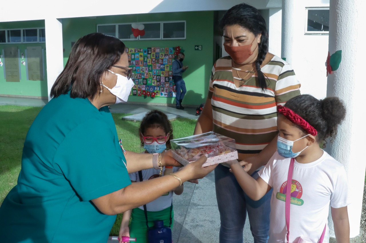 Ao chegar com seus filhos à escola, mãe recebe seu kit de café da manhã